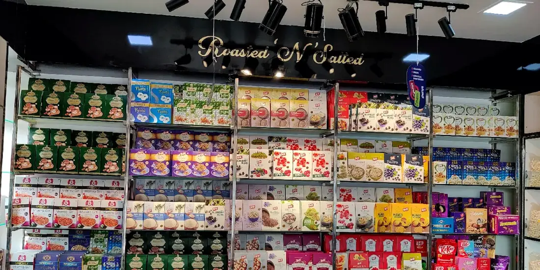 The Roasted ’N’ Salted counter, its name in gold script on a black board above shelves of boxed nuts